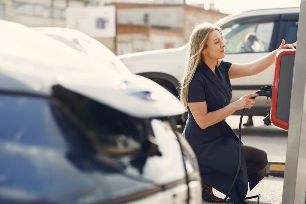 Free Modern woman using station for charging electromobile Stock Photo