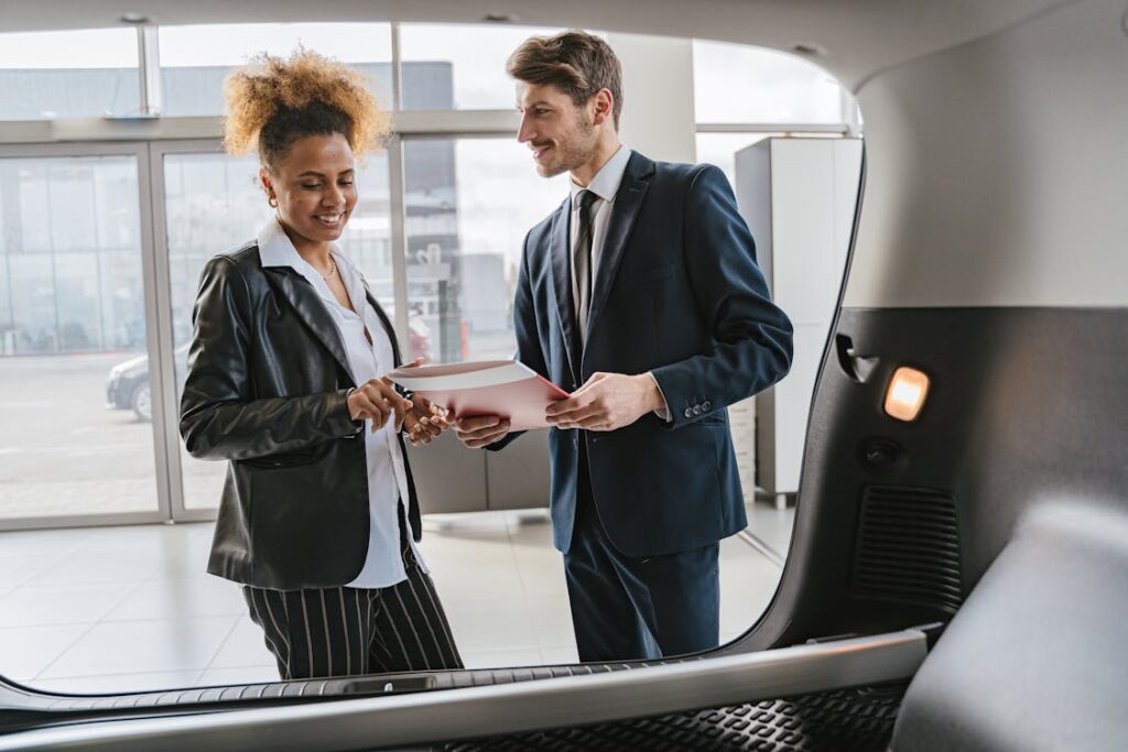 Free Dealer Consulting Client about Car in Salon Stock Photo