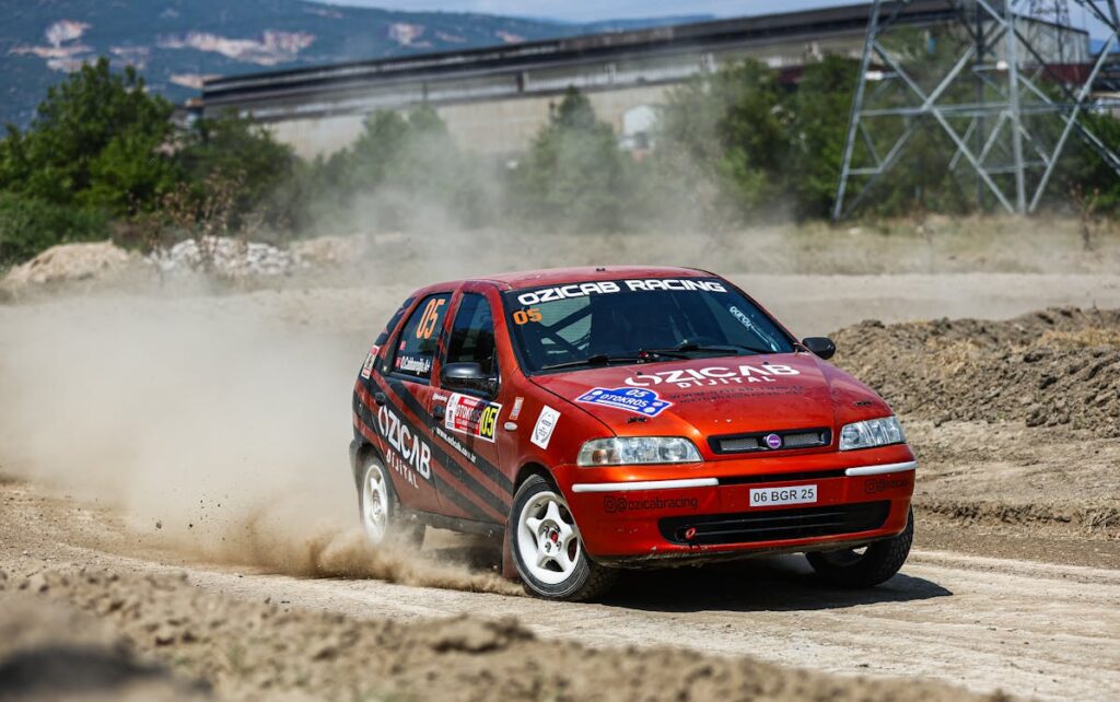 Free A red car driving on a dirt road Stock Photo